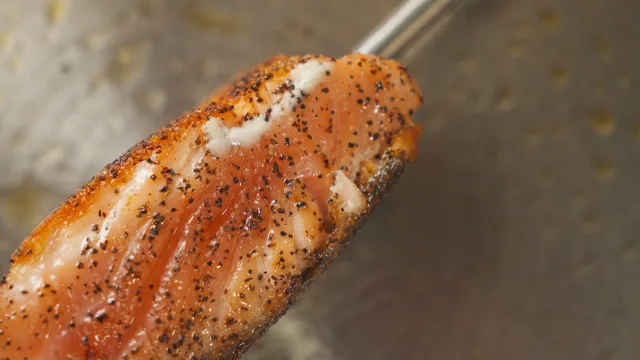 A salmon fillet, skin crisped, lifted on a fish slice