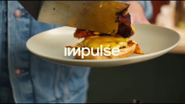 A smash burger on a plate, held to camera